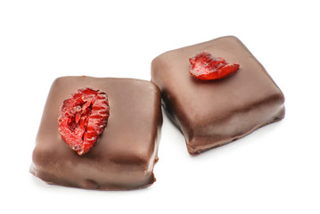Tasty dark chocolate candies with cranberries on white background