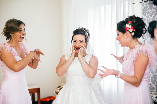 bridesmaid hugging the bride in the bedroom in the morning. Wedding morning for woman. Girls kiss bride. Funny moments.