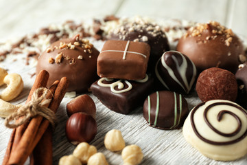 Tasty chocolate candies with nuts and cinnamon sticks, closeup