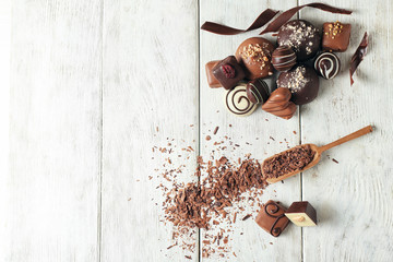 Beautiful composition with tasty chocolate candies on wooden table