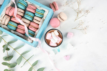 Flat lay composition with tasty macarons, marshmallows and mug of coffee on light background