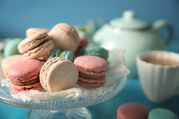 Dessert stand with tasty macarons on table