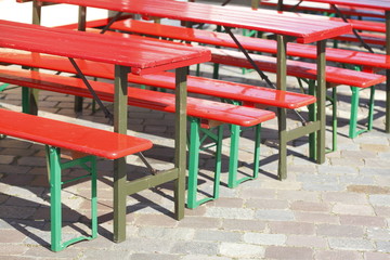 Rote Sitzbänke und Klapptische aus Holz