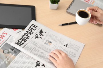 Woman reading morning newspaper at  table