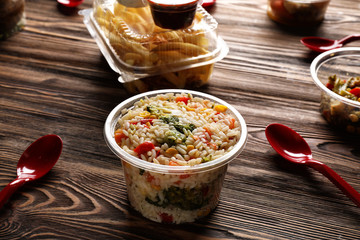 Plastic container with delicious food on wooden table. Delivery service