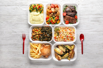 Plastic containers with delicious food on wooden table. Delivery service