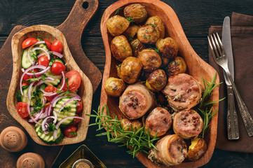 Baked pork medalions in bacon with potatoes.