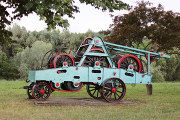 Power unit with wheels, flywheels and chain. Agricultural mechanism for harvest processing. Heavy...