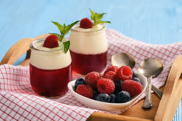 Pannacotta with berry jelly and berries on wooden tray. 