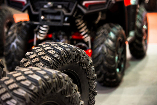 Tires for quad bike with blurry quad bike(four wheeler, quadricycle or all-terrain vehicle) in the background