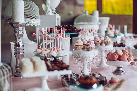 Delicious sweets on candy buffet. Wedding candy bar with a lot of colorful macaroons and another desserts. Wedding party candy bar.