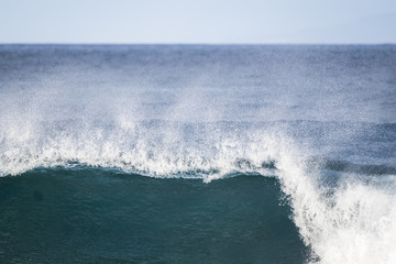 wave crash and go down in the ocean water. white sponge and blue sea perfect for nice surf activity or vacation place