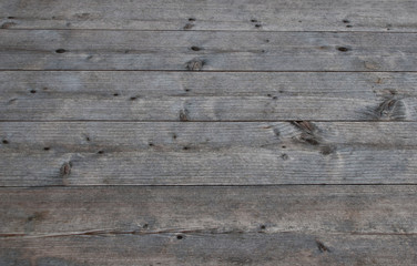 Fototapeta na wymiar Grey natural weathered table of wooden planks as textured background.