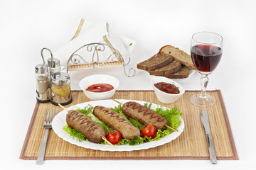 Lula kebab with tomatoes and cucumbers. Serve with black or white bread and a glass of red wine.