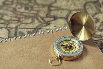 Compass and notebook on blur vintage world map, journey concept, copy space