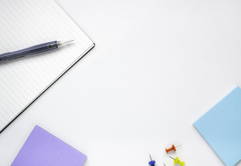 Top view stationary notebook memo and pin on white table background.