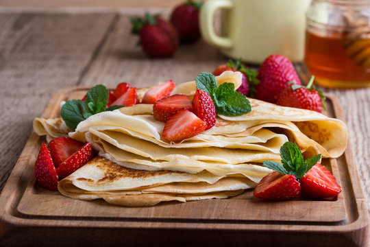 Crepes with fresh strawberries and organic honey for breakfast