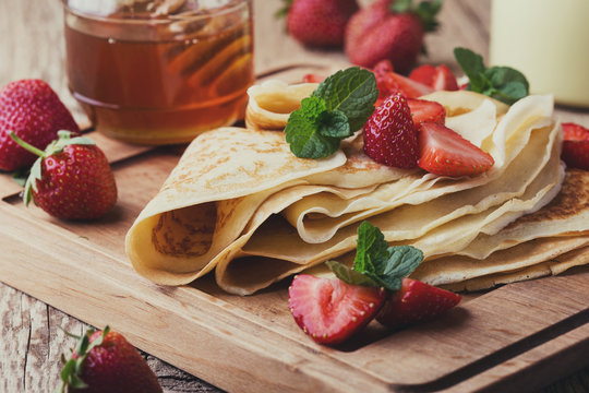 Crepes with fresh strawberries and organic honey for breakfast