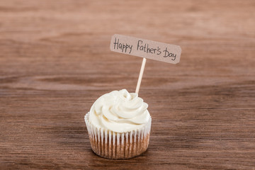 tasty cupcake with Happy fathers day inscription on wooden surface