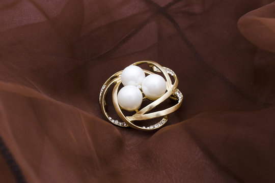 Gold Round Brooch With Pearls And Gems Isolated On Satin