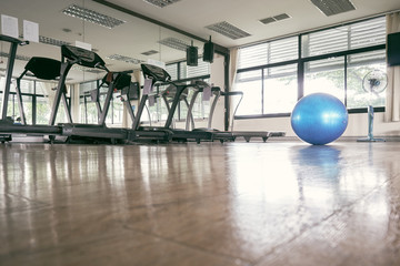 The blue exercise ball placed in the center of the fitness room on the exercise ball floor is for yoga. Various muscle relaxation therapies. vintage tone.