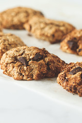 Vegan oatmeal cookies with chocolate on a light background. Healthy vegan dessert. Food blog style concept.