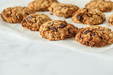 Vegan oatmeal cookies with chocolate on a light background. Healthy vegan dessert. Food blog style concept.