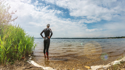 Triathlete standing in a lake before swim