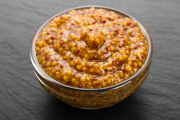 mustard in a bowl on a rustic background