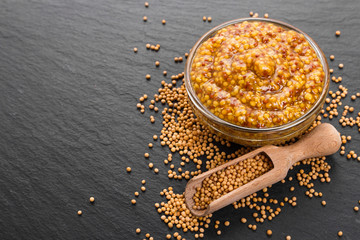 mustard in a bowl on a rustic background
