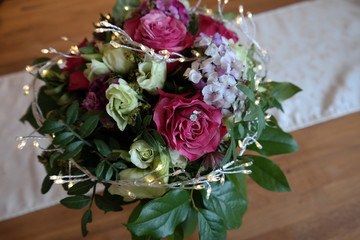 Verlobungsring versteckt in einem romantisch dekoriertem Blumenstrauß