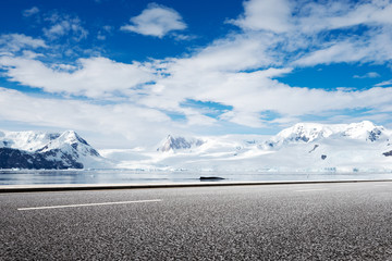 empty asphalt road with snow mountain