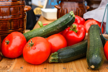 Fresh vegetables - tomatoes and zucchini on a picnic table on a summer day.