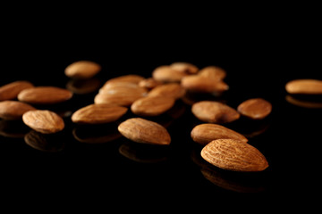Tasty almonds on black background