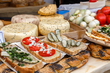 Bread with cheese, cucumbers, tomatoes on picnic table