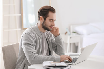 Male freelancer working with laptop in home office