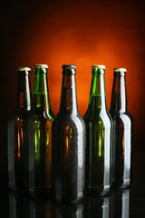 Fresh beer in glass bottles on dark background