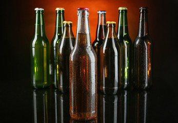 Fresh beer in glass bottles on dark background