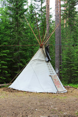 wigwam or teepee standing in summer coniferous forest. © wolfness72