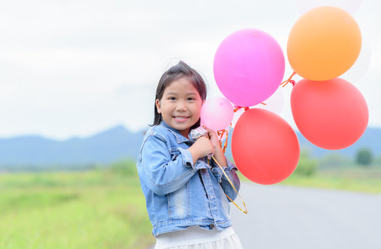 cute asian girl smile and holding balloon,