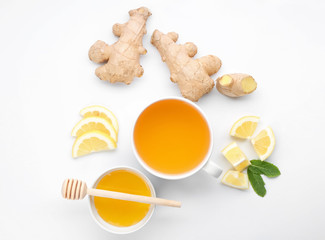 Cup of delicious tea with ginger, lemon and honey on white background