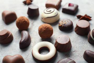 Different tasty chocolate candies on textured table