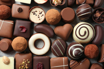 Different tasty chocolate candies on table, top view