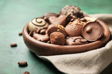 Bowl with different tasty chocolate candies on table