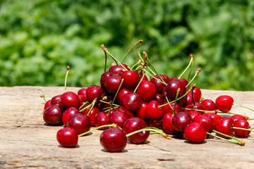 Heap of fresh cherry on rustic wooden table outdoor