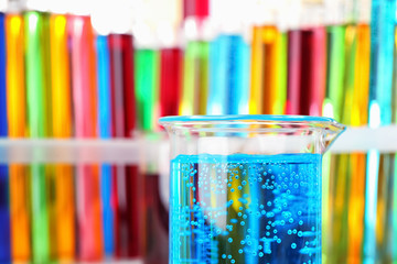 Beaker and test tubes with colorful liquids, closeup