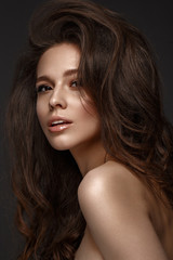 Naklejka premium Beautiful brunette model : volume curls, classic makeup and sexy lips. The beauty face.