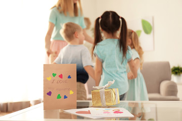 Mother having fun with her cute little children at home