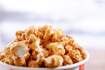 Paper bucket of tasty caramel popcorn, closeup