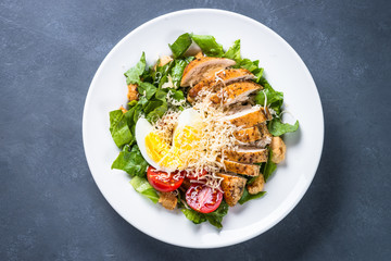 Caesar salad with chicken breast and tomatoes.